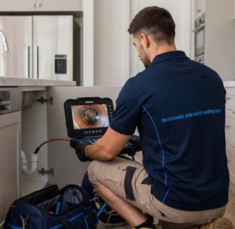 Plumber clearing a blocked toilet in a Kings Park bathroom